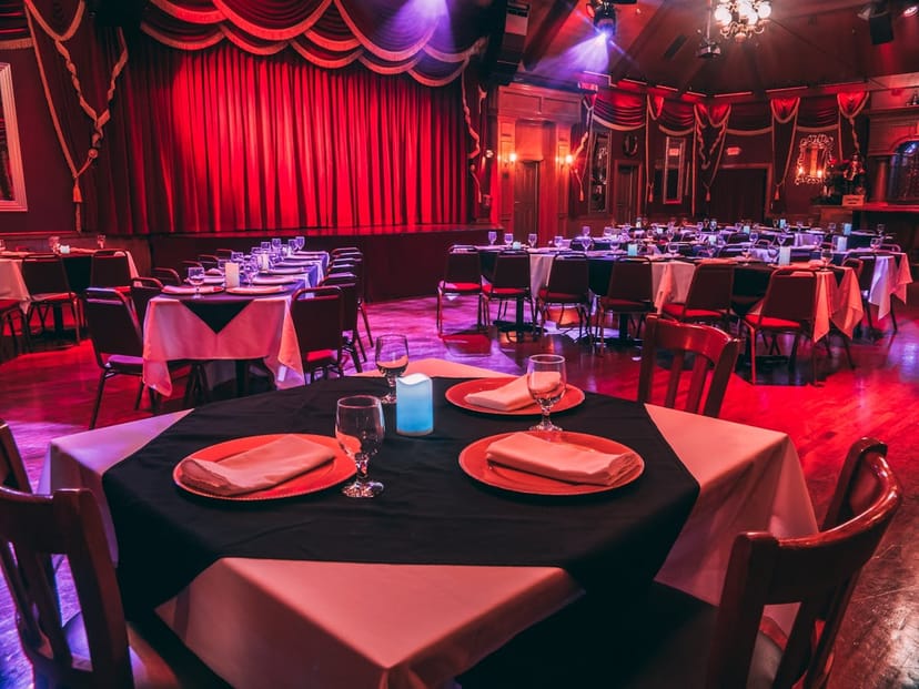 Main Theater at Beach Boulevard Club with elegant black and white table settings for events.