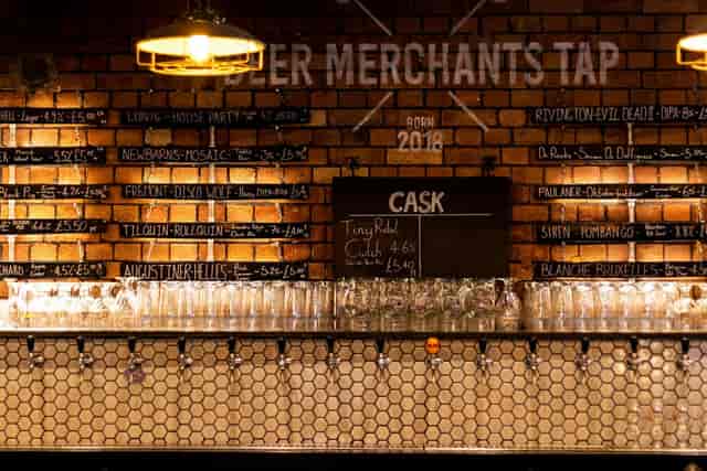 Stylish Taproom bar with brick wall, ideal for networking events and casual gatherings.