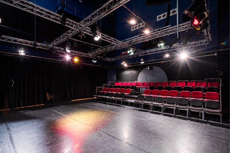 Black Room at The Boardwalk: tiered seating for presentations and performances, ideal for events. - Banner