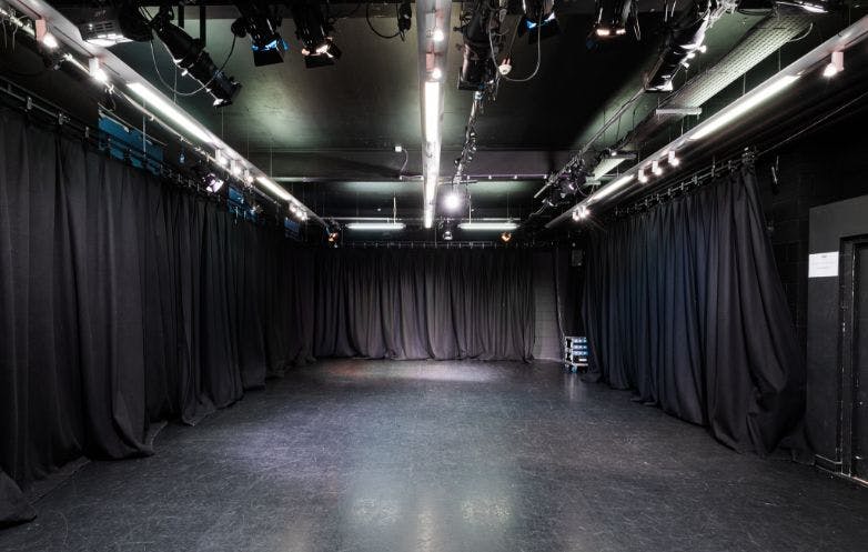 Versatile Black Room event space with minimalist design, ideal for workshops and corporate meetings.