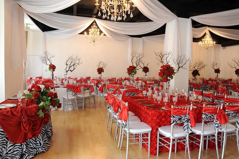 Elegant Quinceañera reception hall in L.A. with red decor and zebra table runners.