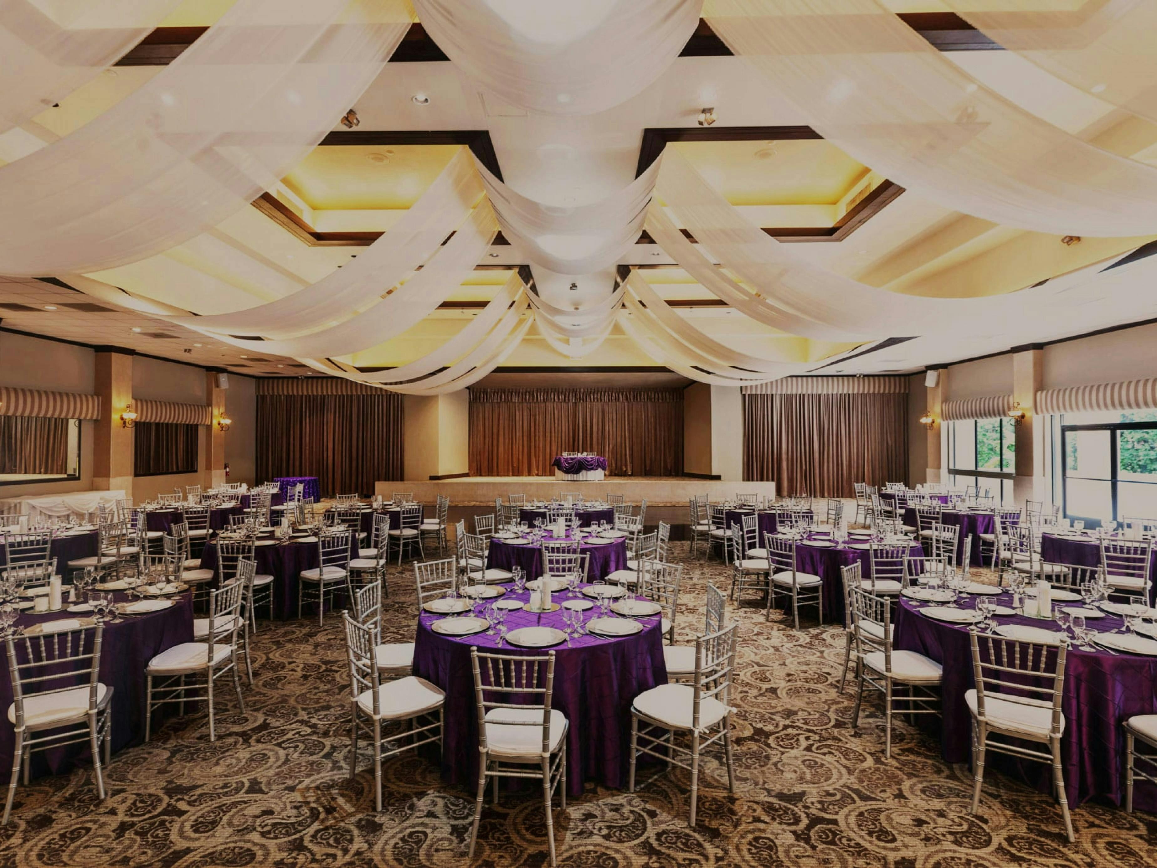 Elegant indoor ballroom with purple linens, perfect for weddings and galas.