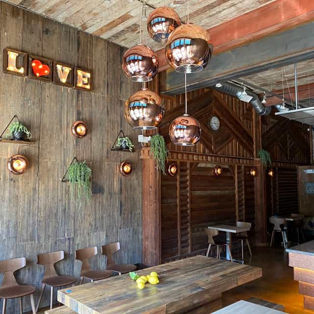 Stylish event space with wooden accents and copper lights, perfect for gatherings and meetings.