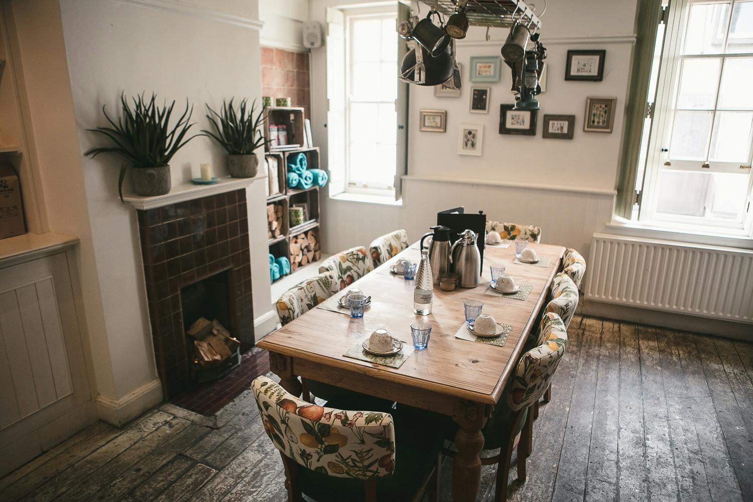 Cozy meeting space with wooden table and floral chairs for workshops or corporate meetings.