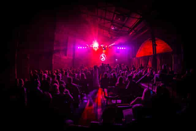 Vibrant event space at Village Underground with dynamic lighting and engaged audience.