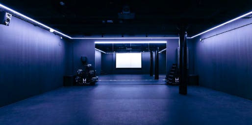 Modern event space with dark walls, ideal for workshops and presentations.