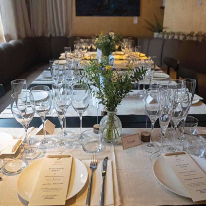 Elegant dining setup with floral centerpiece for events in Bantof's first floor room.
