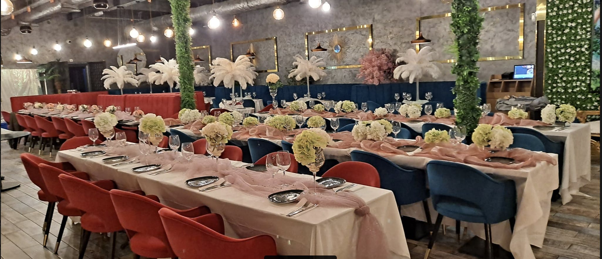 Elegant banquet setup with pink drapery and floral centerpieces for weddings or events.