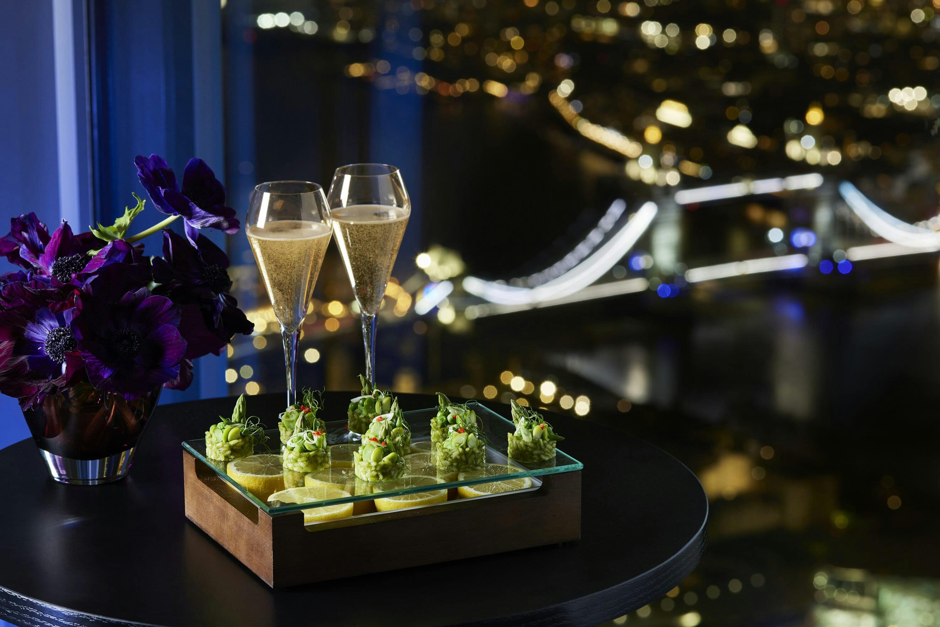 Elegant event setup with gourmet canapés and skyline, perfect for corporate gatherings.