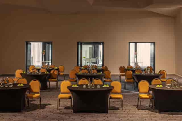 The Marker Suite at Anantara Dublin, featuring round tables and vibrant yellow chairs.