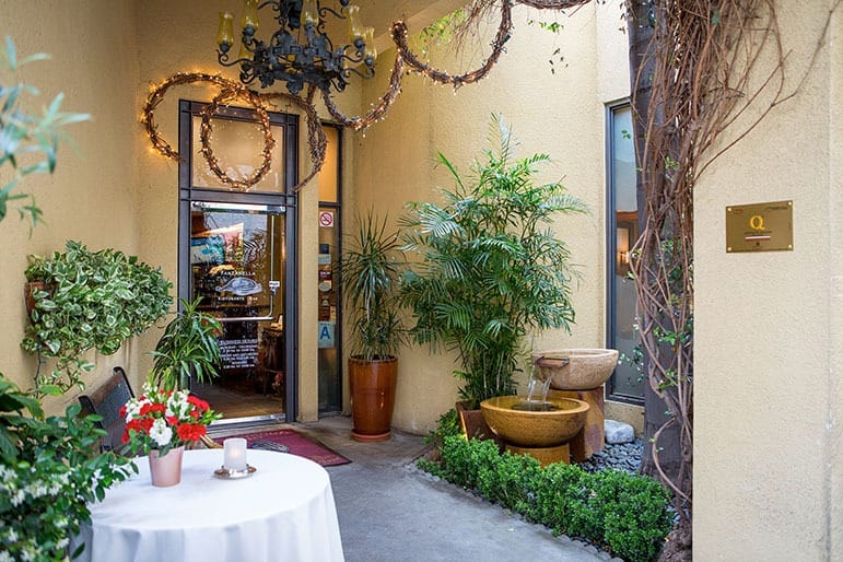 Inviting patio entrance with greenery and water feature for intimate gatherings at Panzanella.