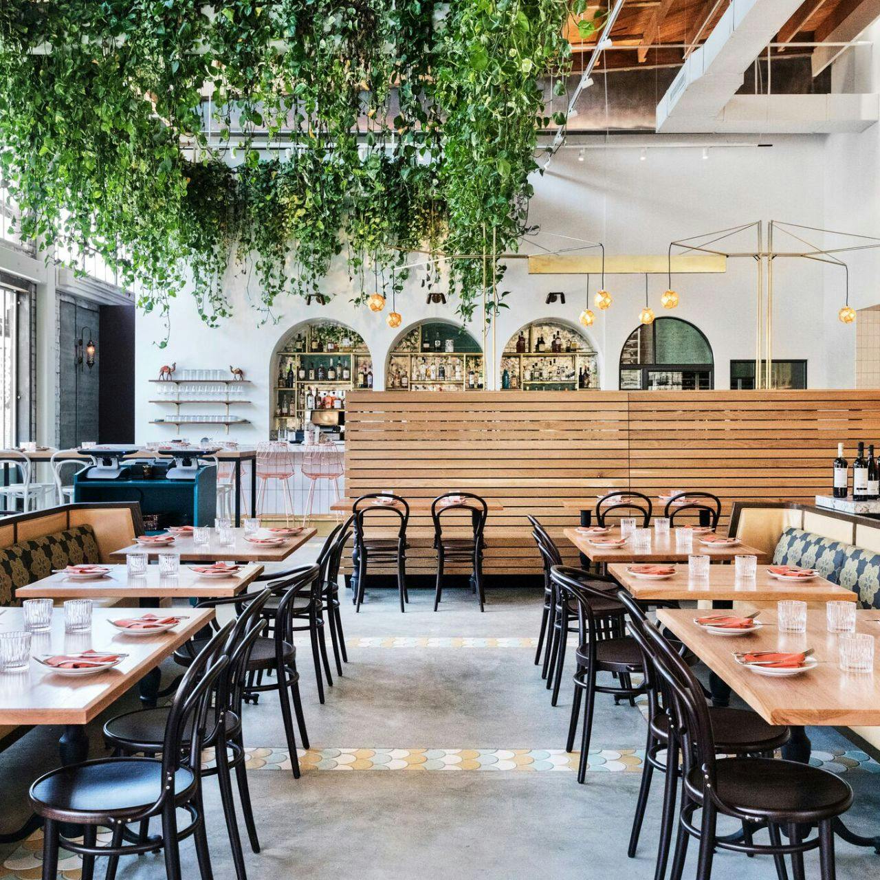 Bavel Restaurant: modern dining space with wooden tables, ideal for events and gatherings.