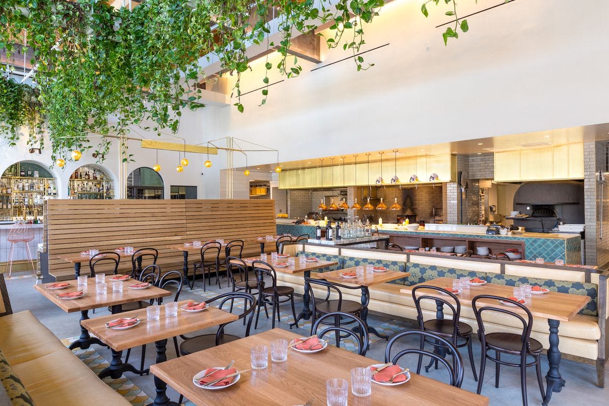 Modern Main Dining Room in Bavel, ideal for events with stylish wooden tables and greenery.