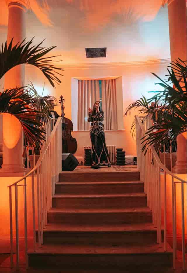 Full House Takeover performance at Knotel Workclub, featuring lush greenery and elegant ambiance.