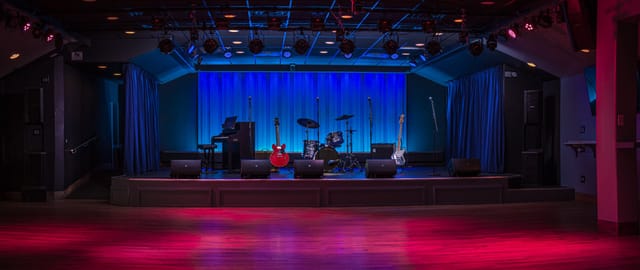 Main floor bar stage with blue backdrop, ideal for live concerts and events.
