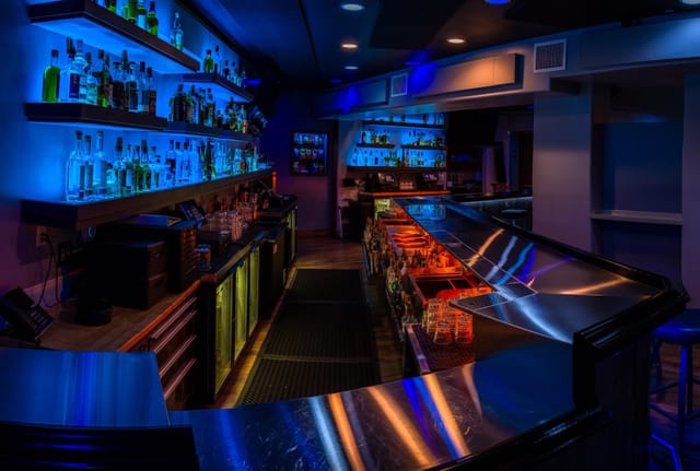 Sleek modern bar with blue lighting, perfect for networking events and cocktail receptions.