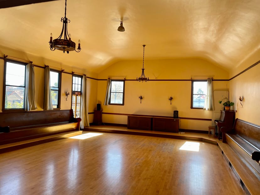 Spacious meeting room with warm yellow walls, ideal for events and gatherings.