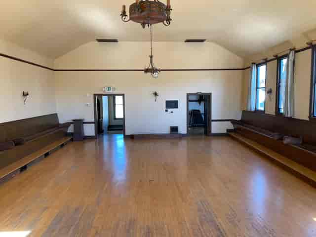 Spacious meeting room with wooden benches, ideal for workshops and social events.