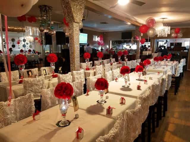 Elegant event space at Lavender Blue Lounge with red floral centerpieces for celebrations.