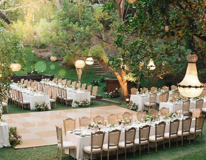 Elegant outdoor wedding dance floor with floral centerpieces in Los Angeles garden.