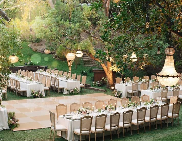 Elegant outdoor wedding dance floor with floral centerpieces in Los Angeles garden.