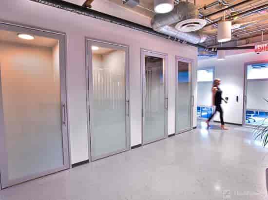 Modern office space with glass-walled meeting rooms for collaborative meetings.
