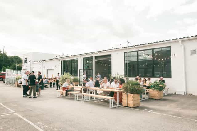 Vibrant outdoor event space with communal tables, ideal for gatherings and networking.