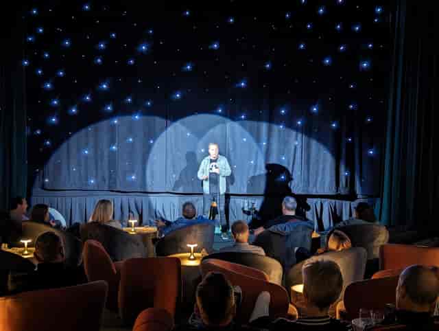 Dynamic speaker engaging audience in cozy Cinelounge bar setting, ideal for events.