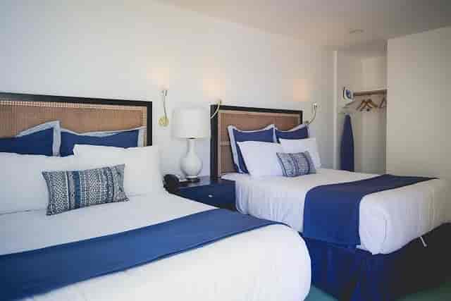 Modern hotel room with two beds, ideal for post-conference relaxation and events.