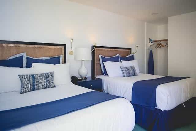 Modern hotel room with two beds, ideal for post-conference relaxation and events.
