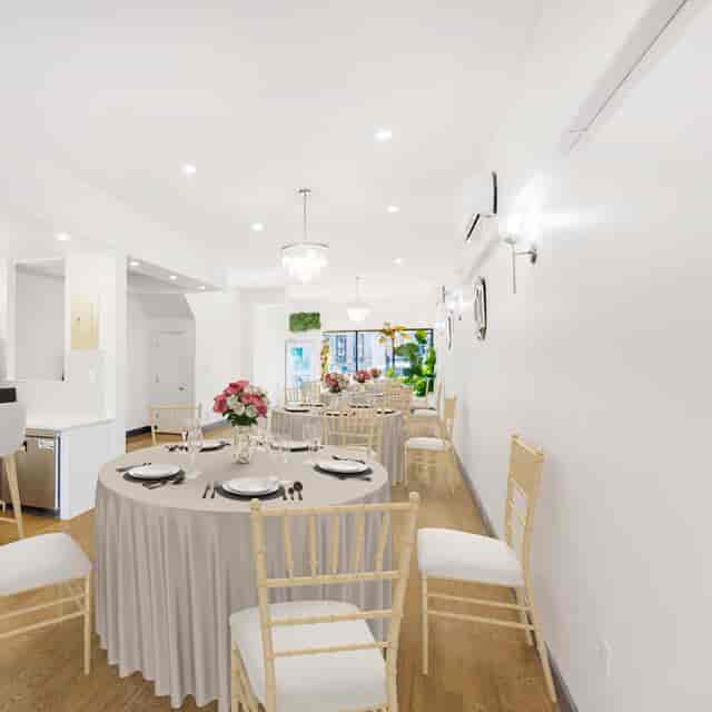 Elegant private dinner setup with floral centerpieces in a bright event space.