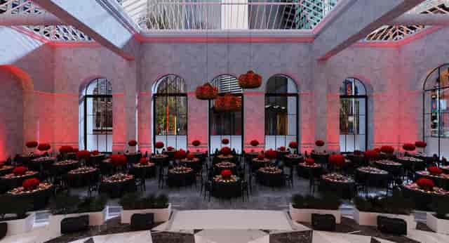 Elegant event space with round tables and red floral centerpieces at One Sansome.