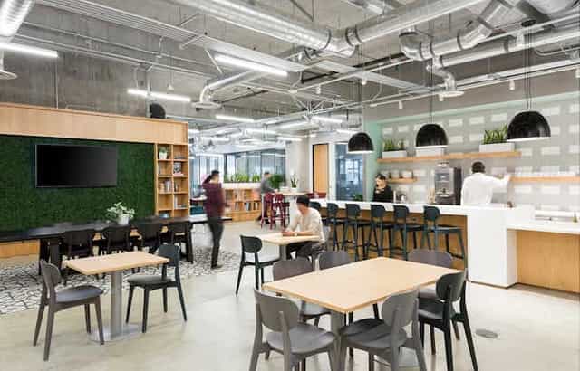Modern coworking area with greenery wall, ideal for networking events and collaboration.