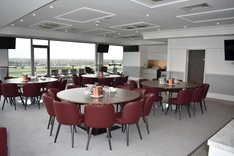 Royal Box at Sandown Park: modern meeting space with round tables for events and networking.