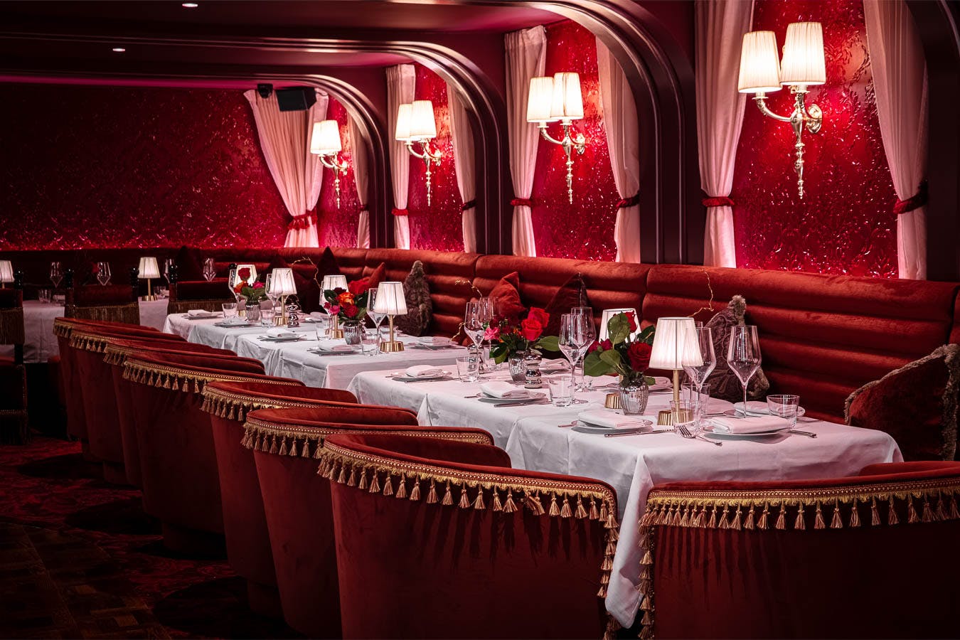 Elegant semi-private dining area with rich red decor for upscale events and gatherings.