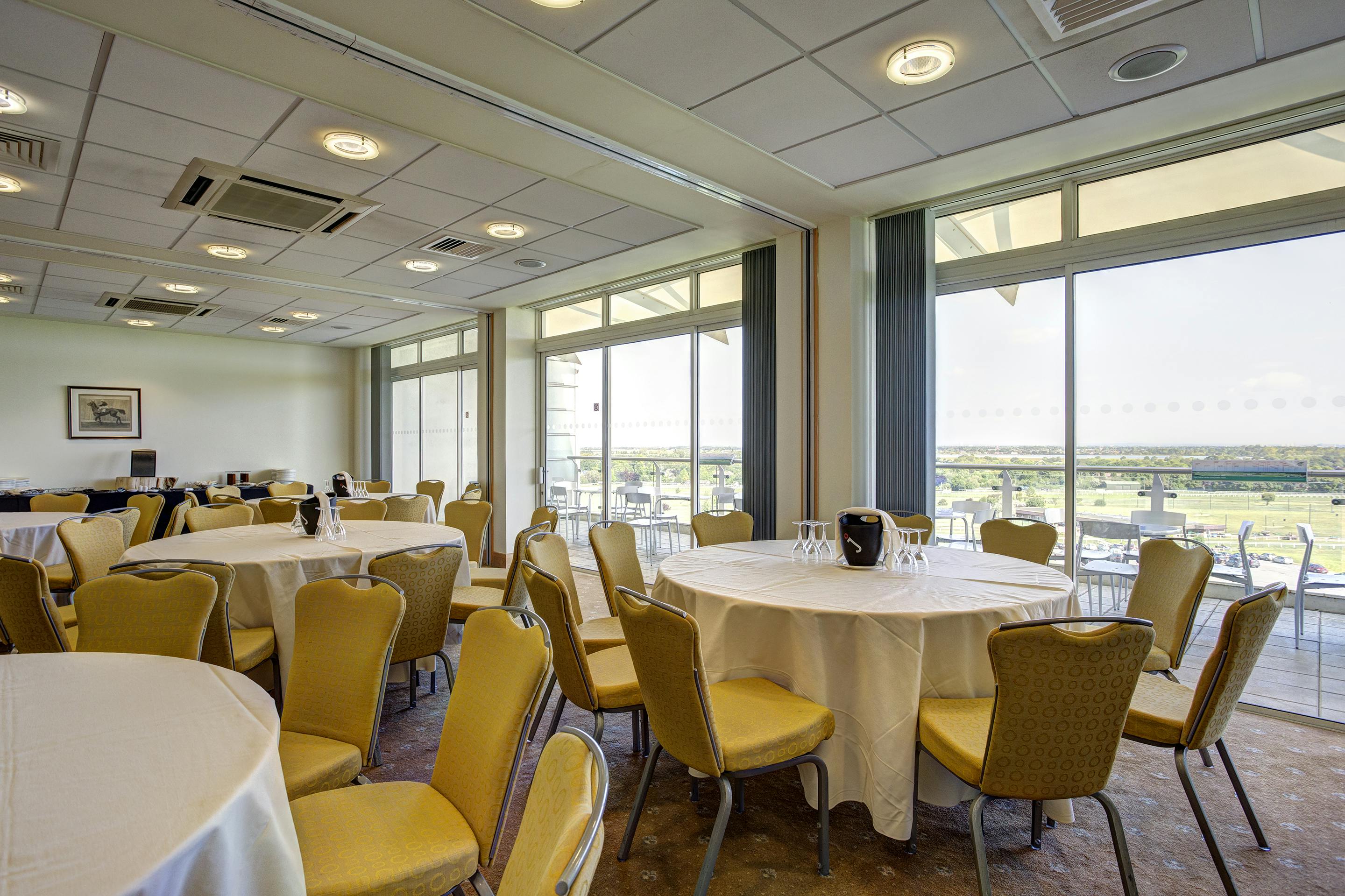 Eclipse Triple Box at Sandown Park: bright event space with round tables for meetings and gatherings.