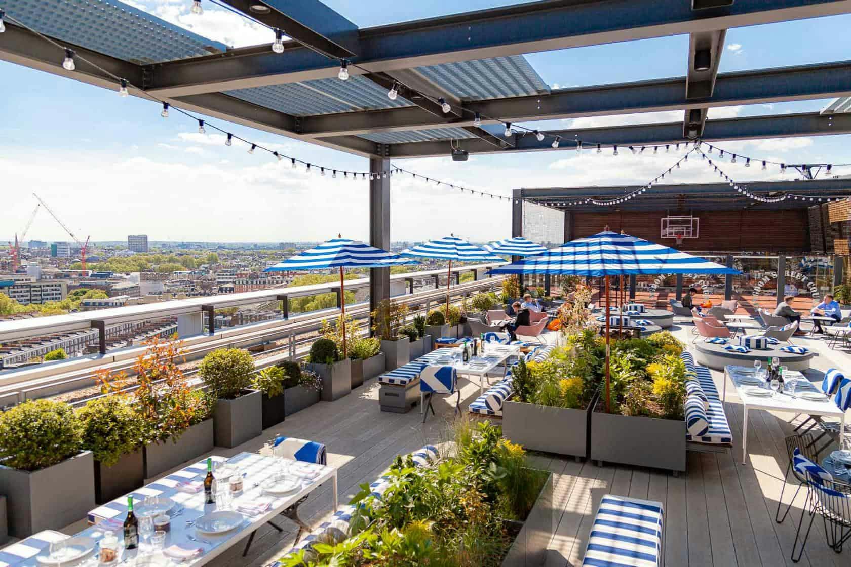 Skylark Rooftop Bar with blue umbrellas, perfect for events and gatherings.