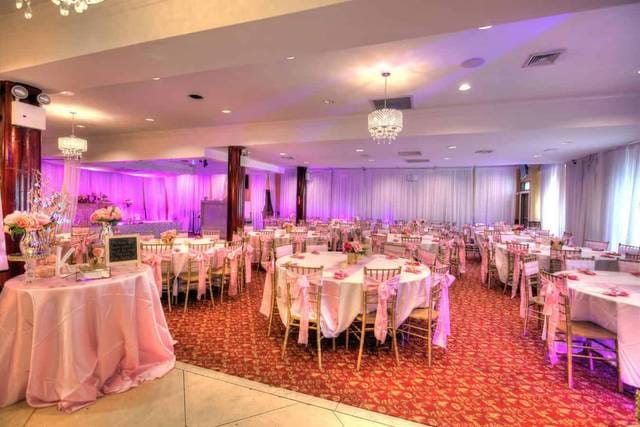 Elegant event venue with soft pink lighting, ideal for weddings and formal gatherings.