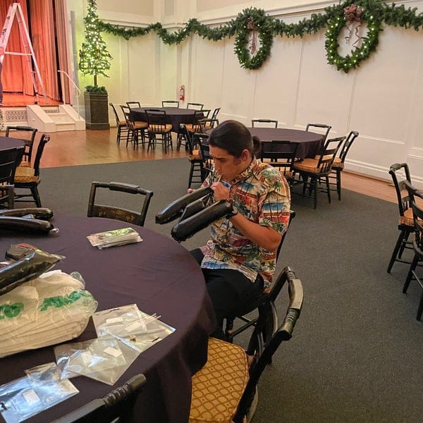 Event professional preparing formal setup at Century Club of California for a celebration.
