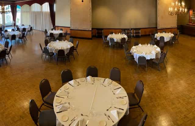 Elegant Solarium venue with round tables, perfect for banquets and corporate events.