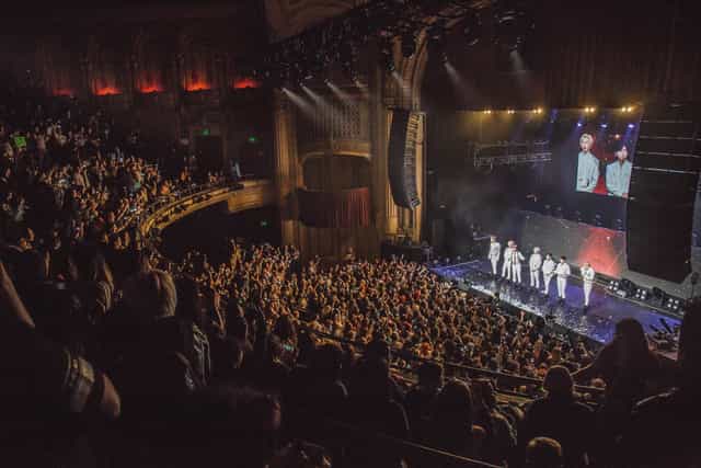 Vibrant live concert at The Warfield with engaged audience and professional stage setup.