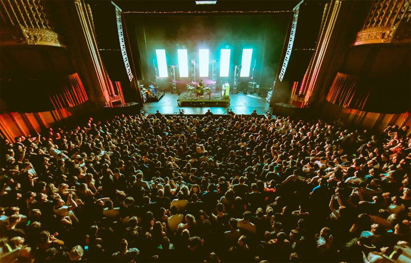Packed Warfield auditorium during a live concert with vibrant stage lighting.