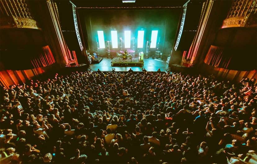Packed Warfield auditorium during a live concert with vibrant stage lighting.