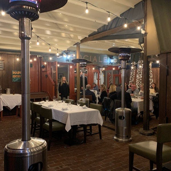 Cozy dining space with string lights, perfect for intimate gatherings and corporate events.