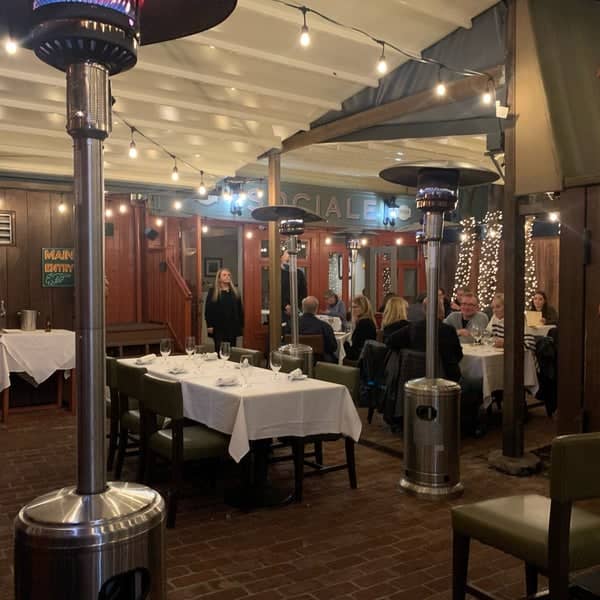 Cozy dining space with string lights, perfect for intimate gatherings and corporate events.