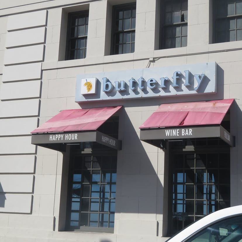 Majestic Butterfly Lounge exterior with happy hour signage, ideal for networking events.