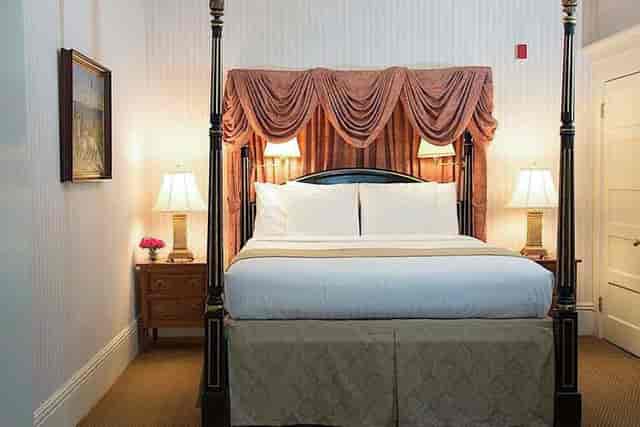 Luxurious four-poster bed in The Majestic Butterfly Lounge, perfect for business events.