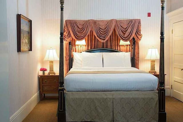 Luxurious four-poster bed in The Majestic Butterfly Lounge, perfect for business events.