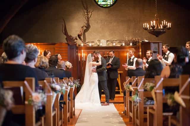 Wedding ceremony in Luscious Garden, warm lighting and rustic decor create romance.