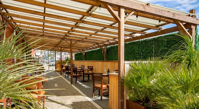 Private event space at Amoura Restaurant with greenery, ideal for casual meetings and gatherings.